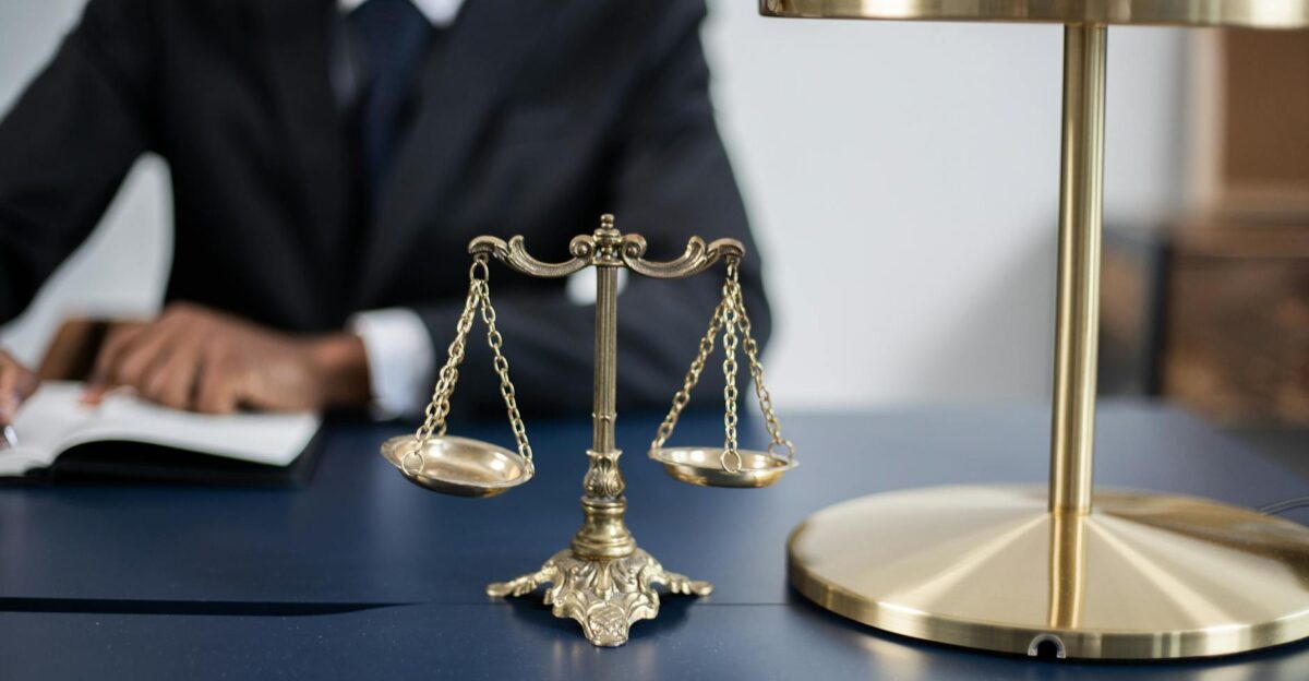 Elegant legal office with a close-up of golden scales of justice on a sleek dark desk