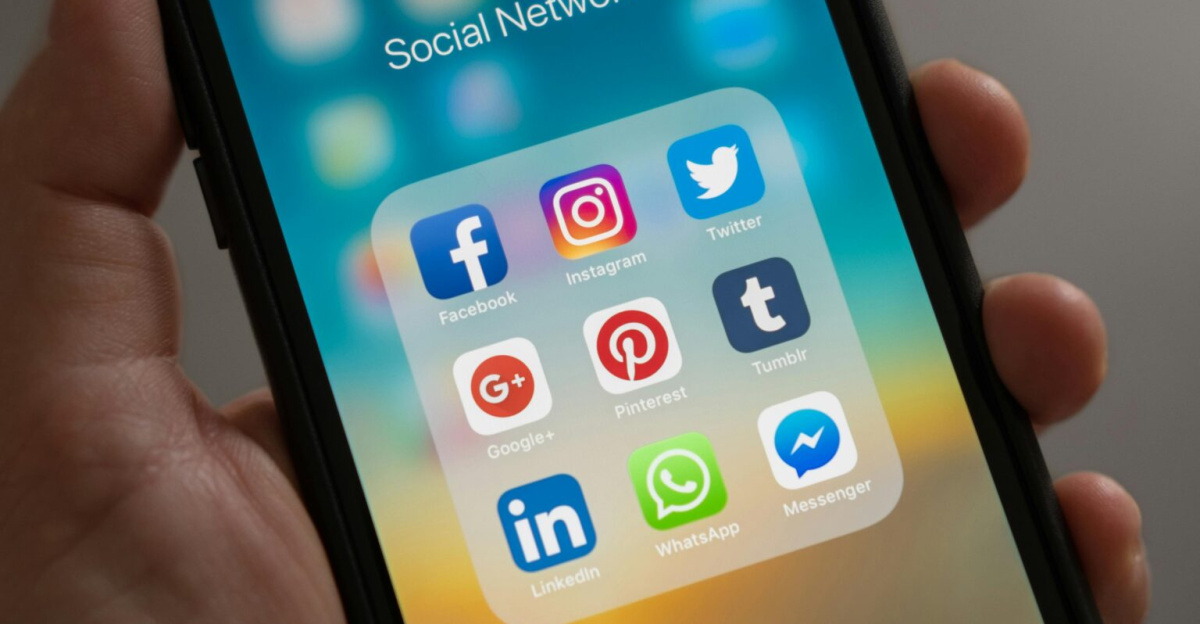 A smartphone displaying various social media icons held in a hand, showcasing modern communication apps.