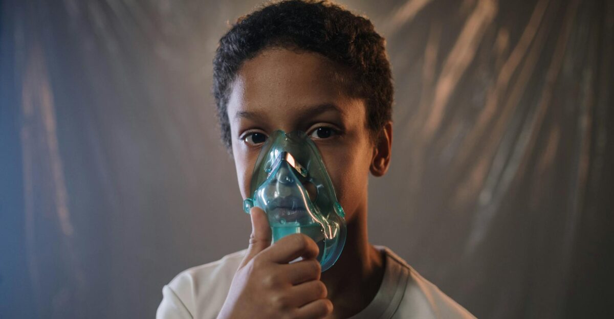 Portrait of a child using an oxygen mask indoors highlighting health care needs