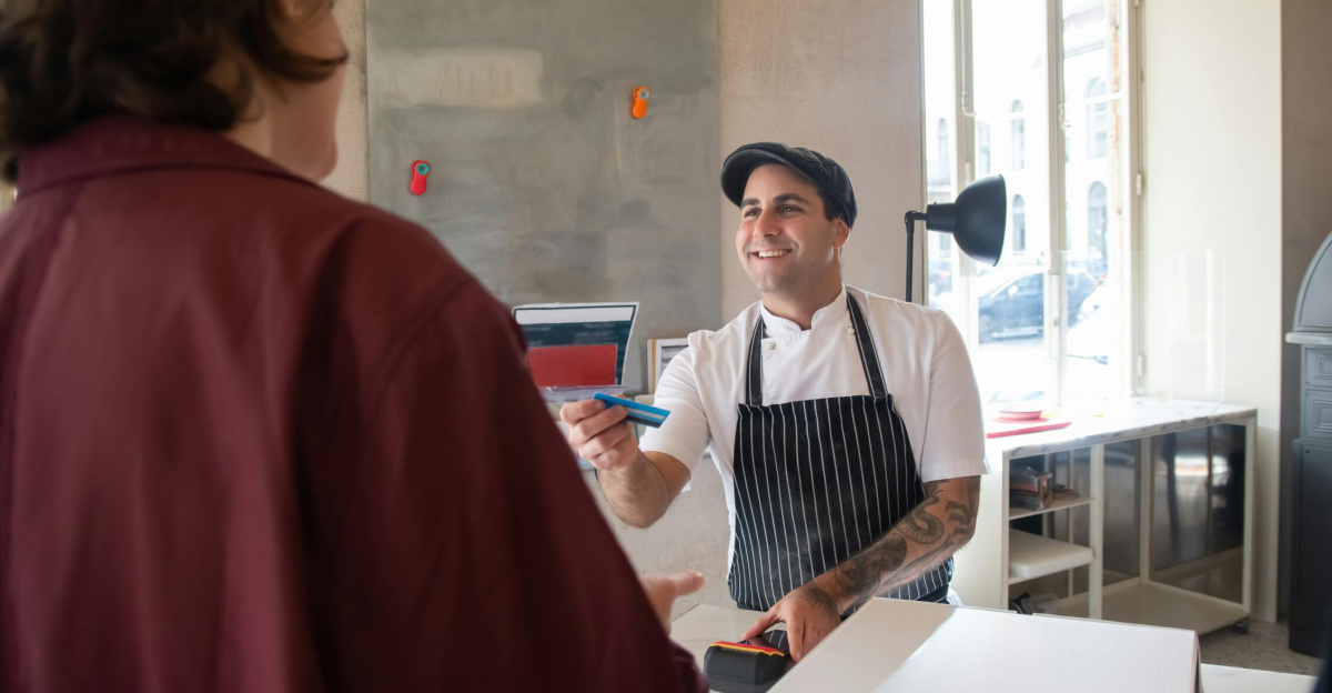 Chef smiling while serving a customer at a pizzeria in Portugal.