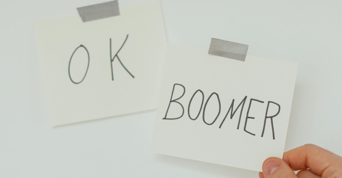 A hand holding a sticky note with the popular phrase 'OK Boomer', illustrating generational dialogue.