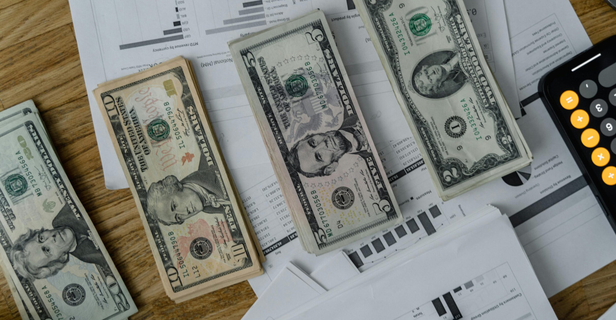 A workspace setup featuring cash, documents, and a calculator symbolizing financial analysis and budgeting.