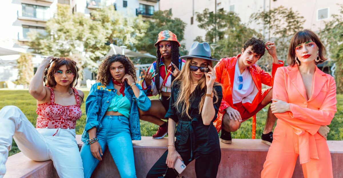 A diverse group of stylish young adults posing together in an urban outdoor setting