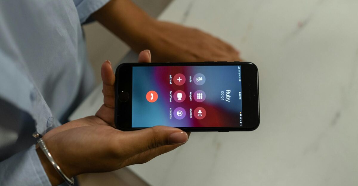 Close-up of a person holding a smartphone displaying an incoming call screen