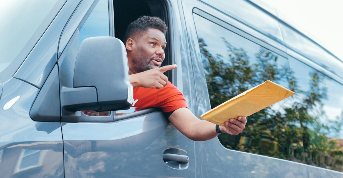 Courier in a van delivering a package through the window on a sunny day