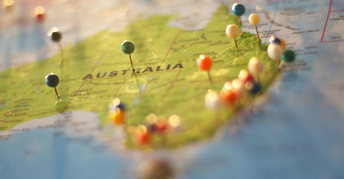 Close-up of a map of Australia with colorful pins marking various cities and destinations