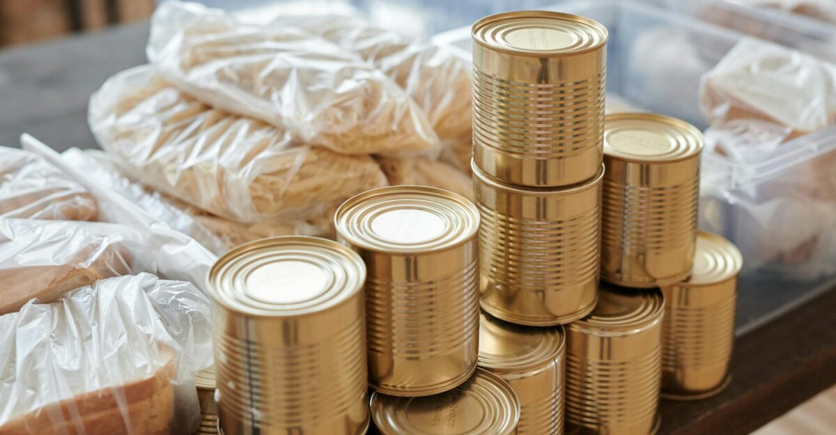 A stack of canned goods and packaged foods on a table perfect for donation drives