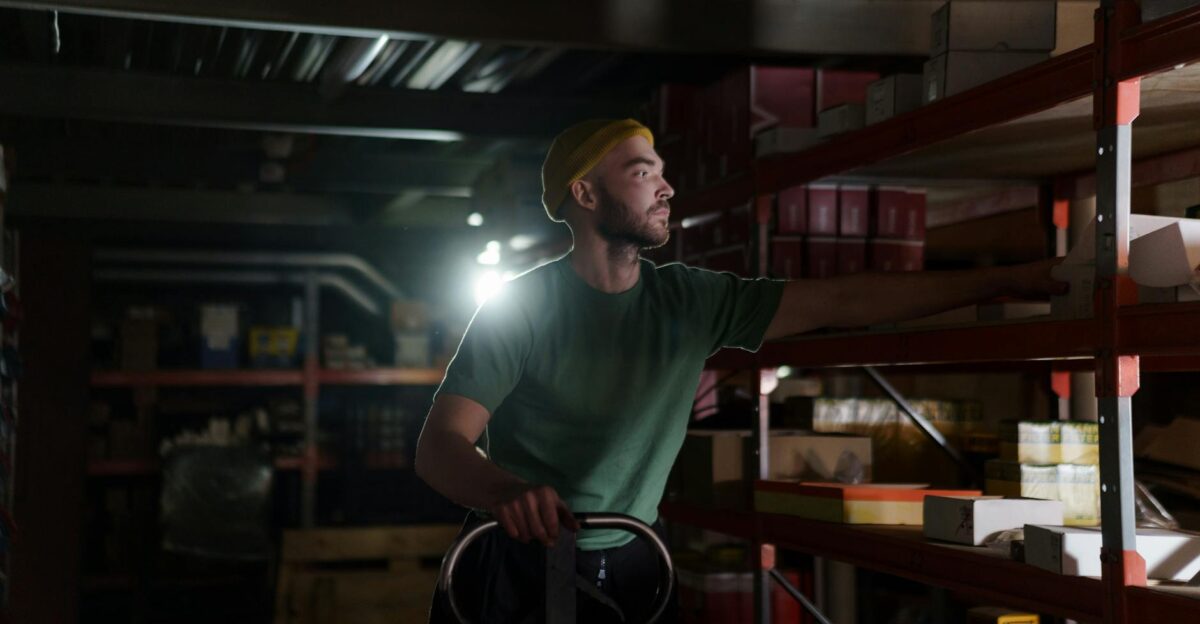 A dedicated worker organizing inventory on warehouse shelves with focused concentration