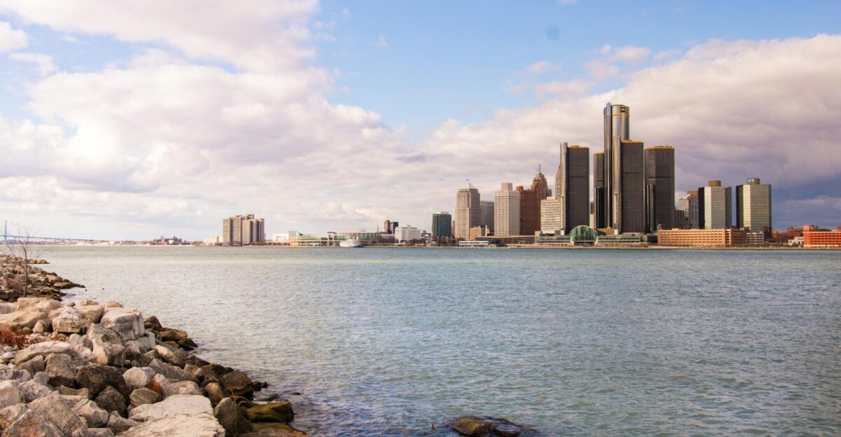 View of the Detroit skyline across the river on a clear day with rock-strewn waterfront
