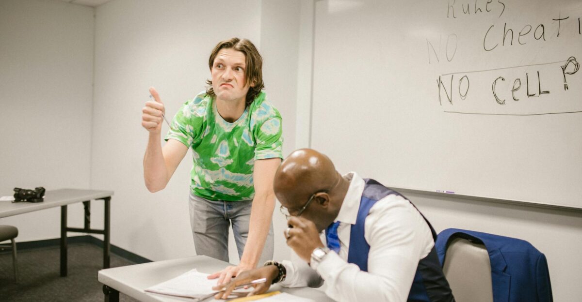 A teacher catches a student attempting to cheat with a hand signal during a classroom exam