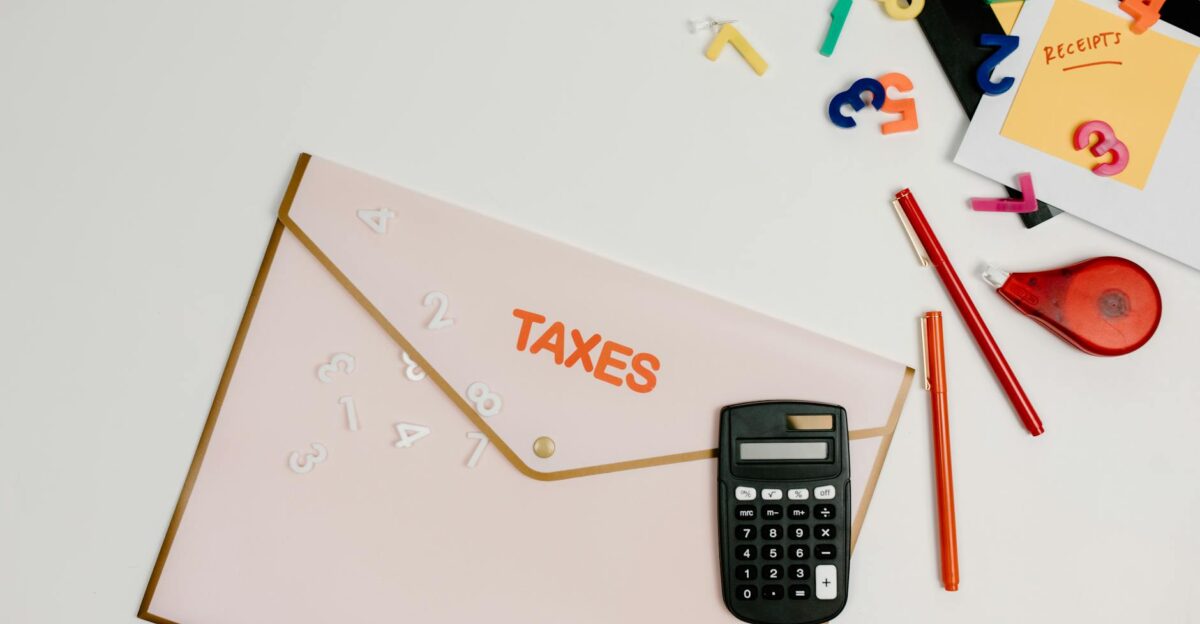 Flat lay of a tax preparation workspace with calculator envelope and colorful numbers