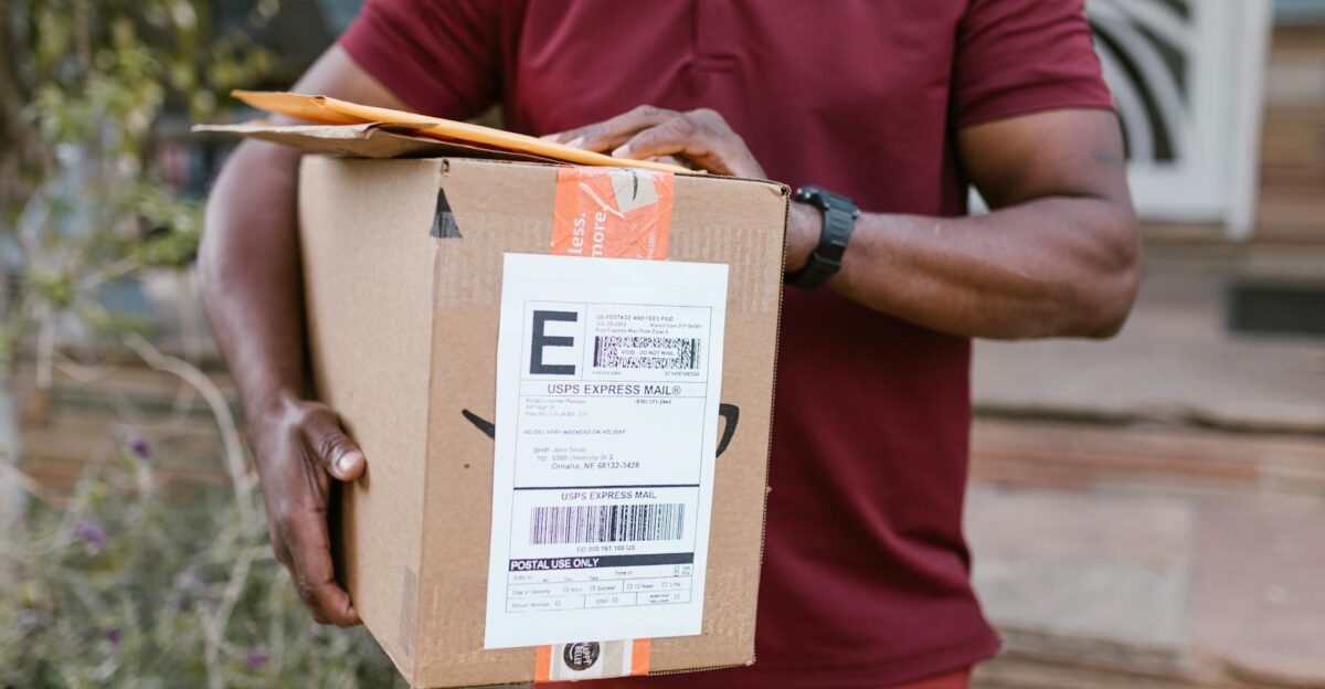 Close-up of a courier delivering a parcel with USPS express mail label outdoors