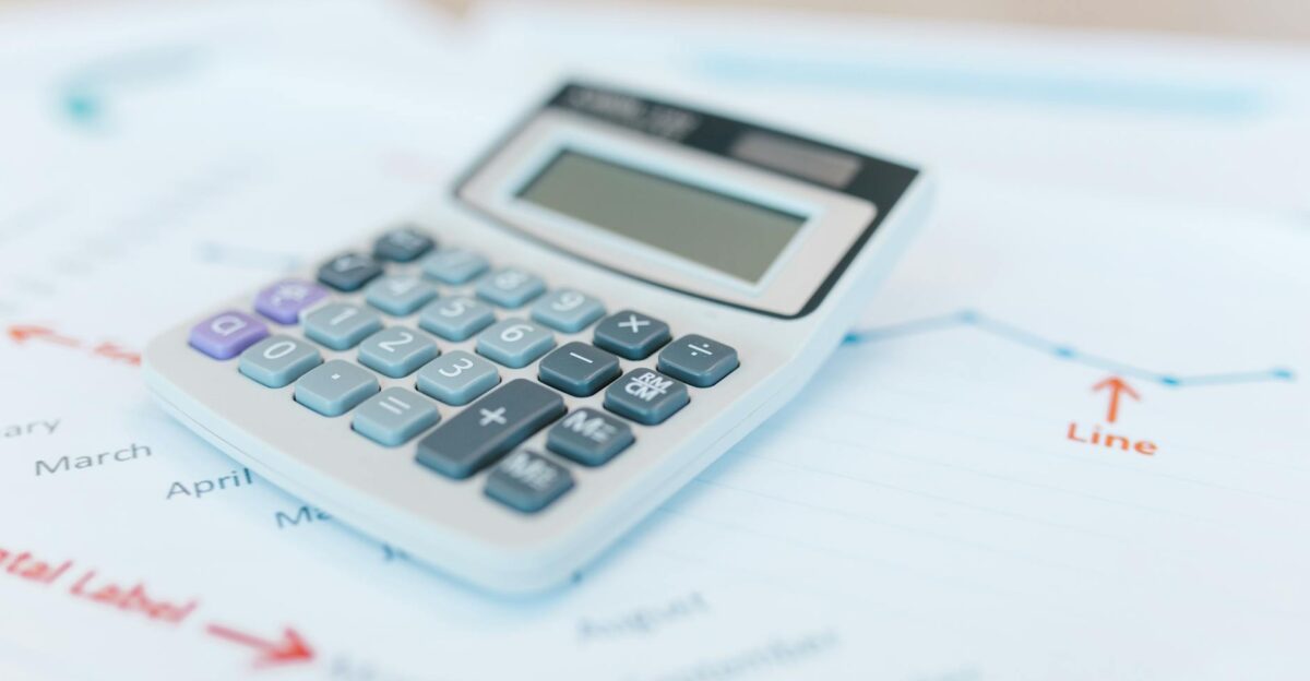 Close-up of a calculator on financial documents with graphs and analysis papers