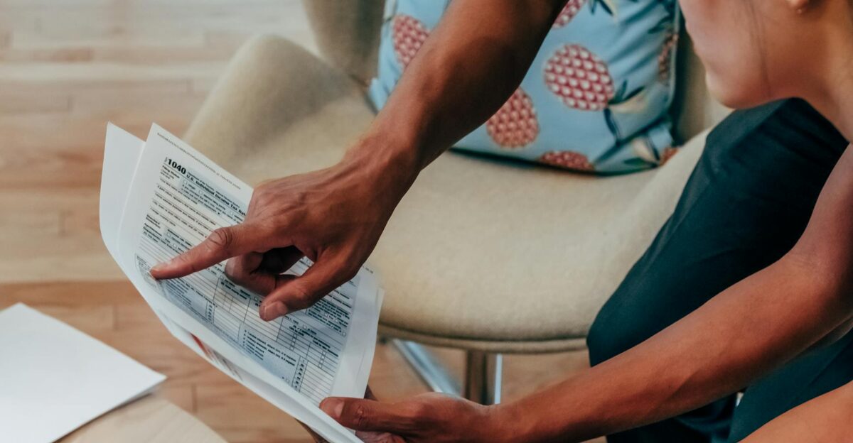 Two individuals examining financial documents closely focusing on detail