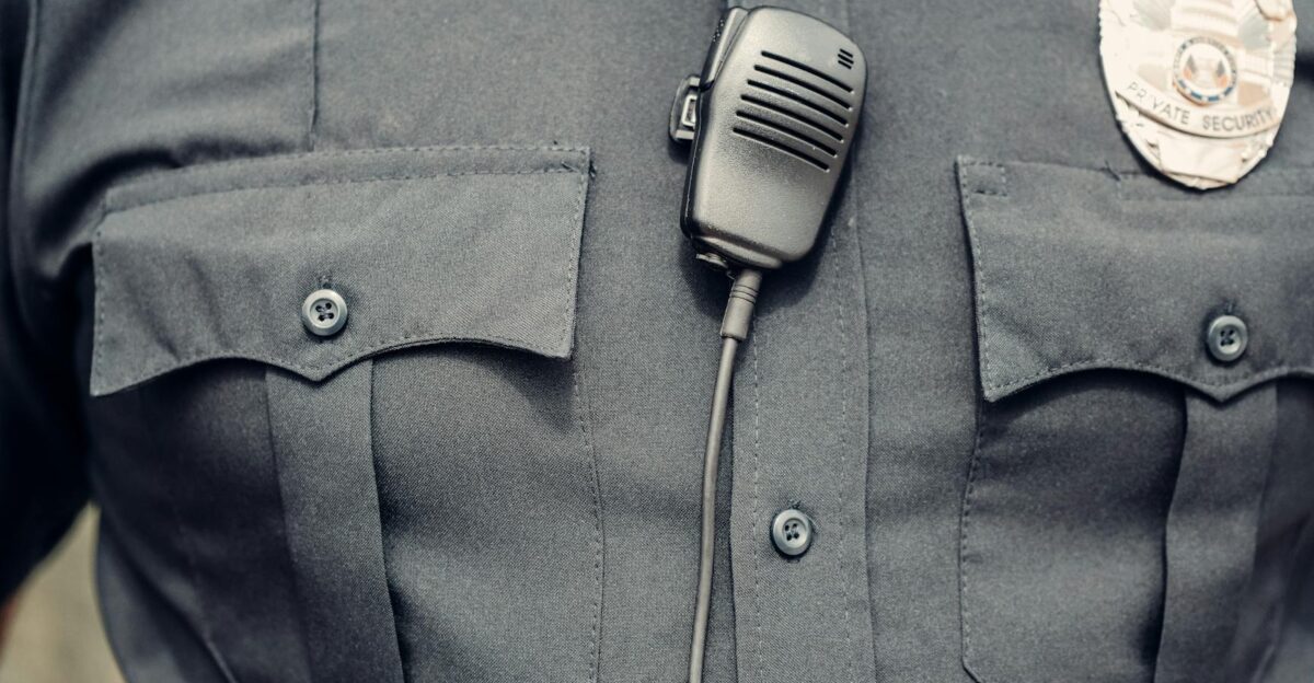Close-up of a police officer s uniform featuring a body camera and badge