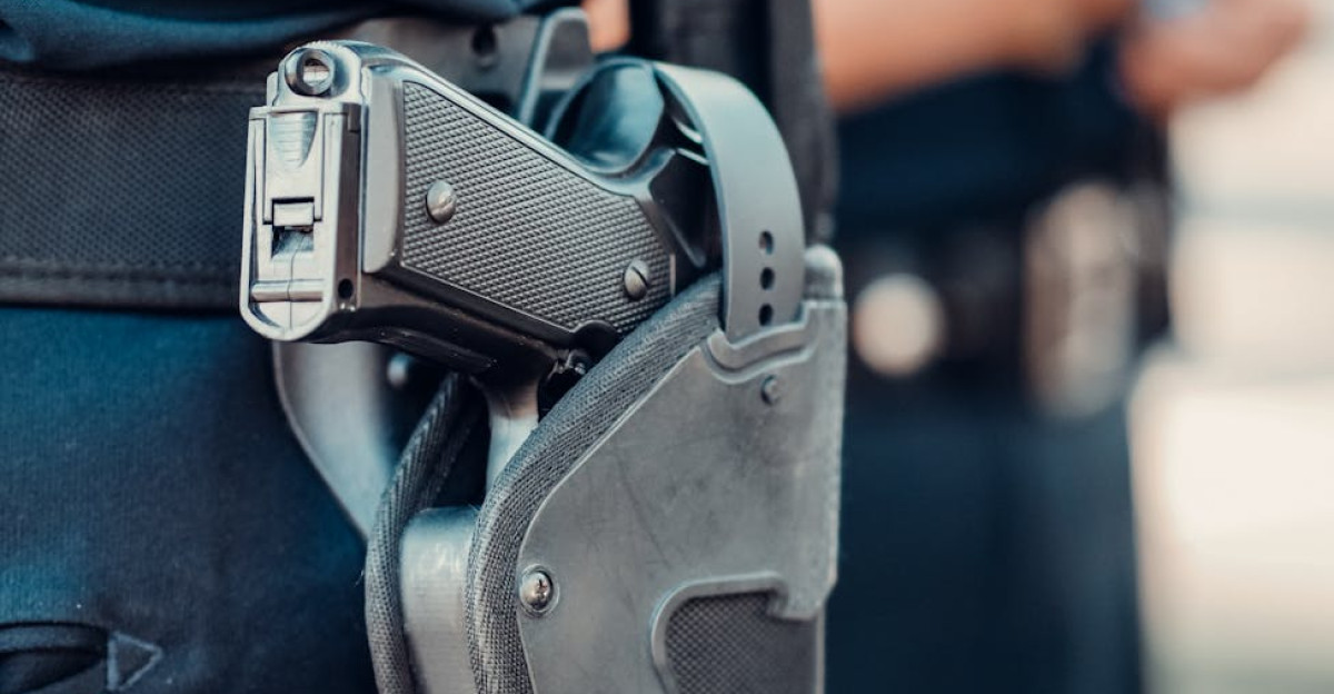 Detailed view of a police officer s gun holstered on the belt with blurred background