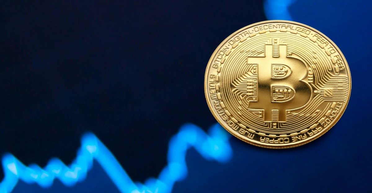 A gold Bitcoin coin against a backdrop of a digital financial chart, symbolizing cryptocurrency trading.