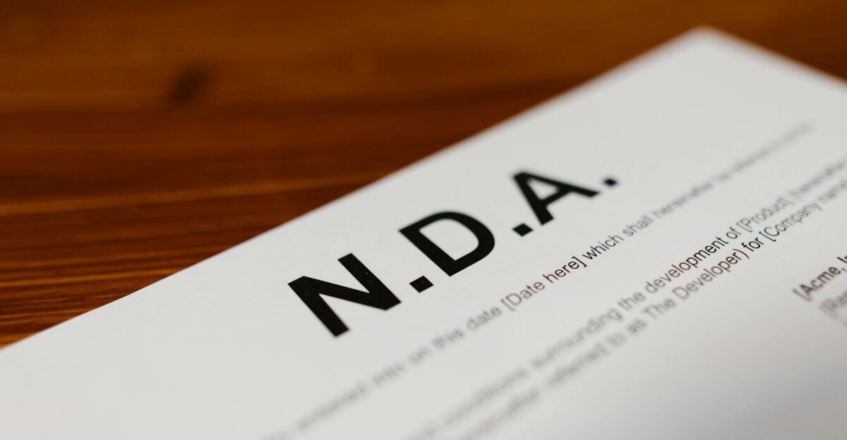 Focused close-up of an NDA document on a wooden desk highlighting contract details
