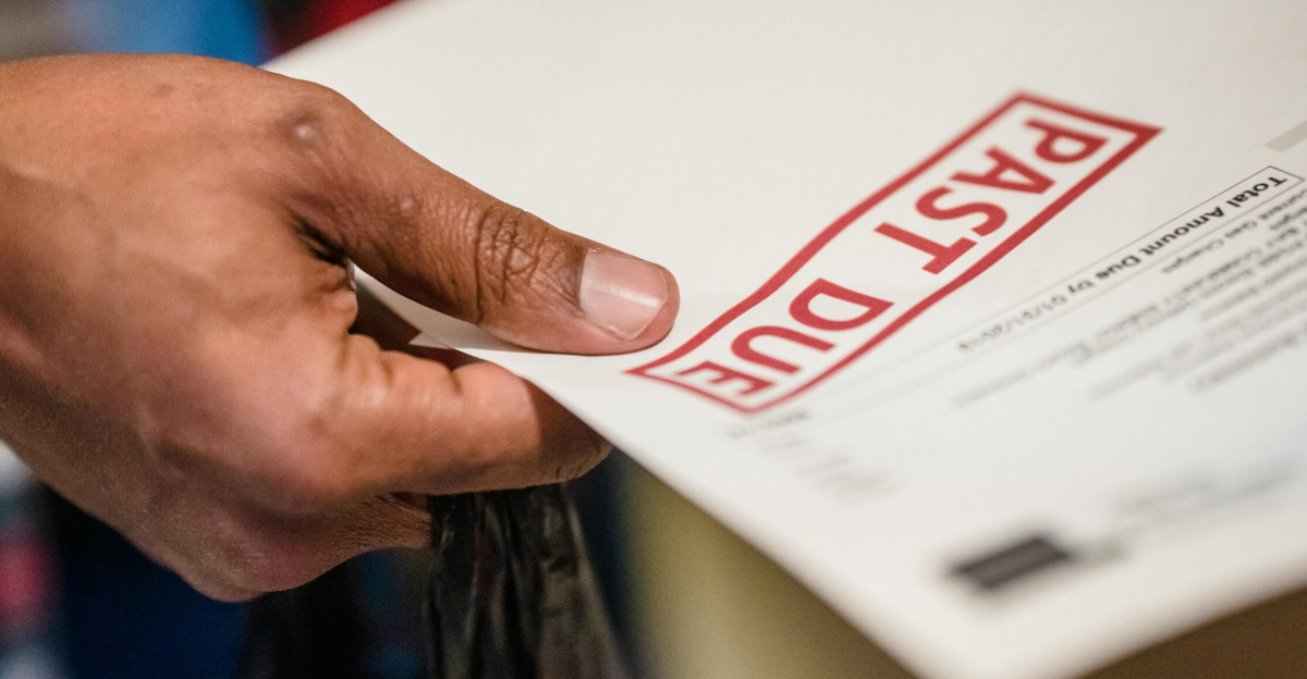 A close-up of a hand holding a document with a 'Past Due' stamp, highlighting financial urgency.