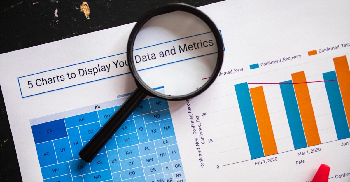 Close-up of business charts with magnifying glass highlighting data insights