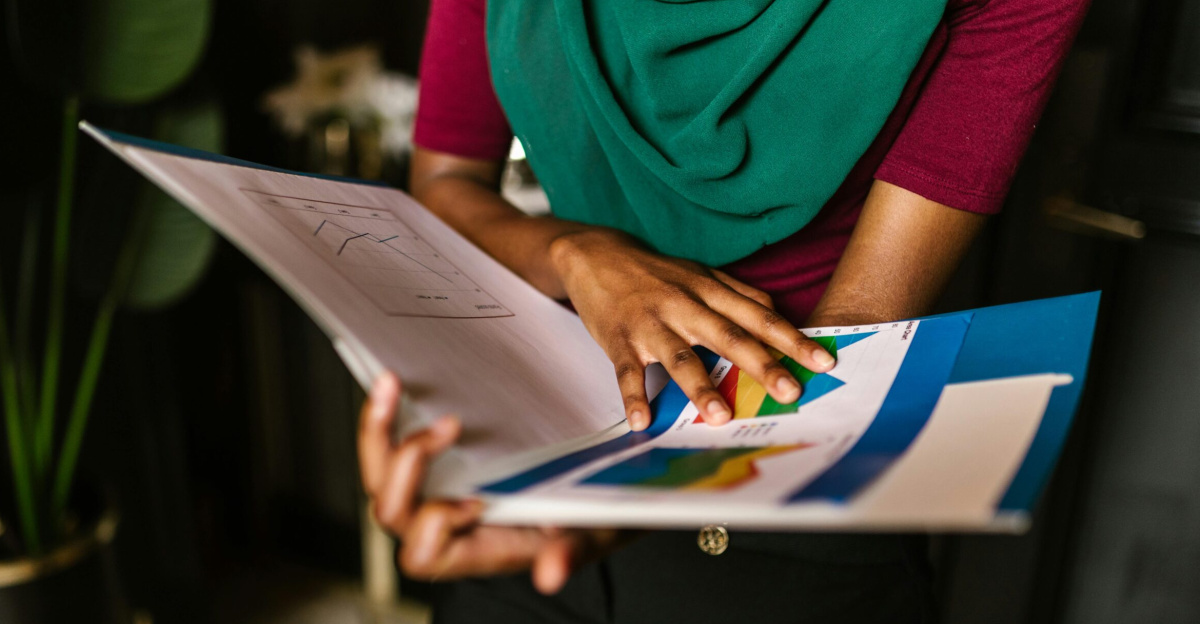 Close-up of a person reviewing charts and reports in an office setting.