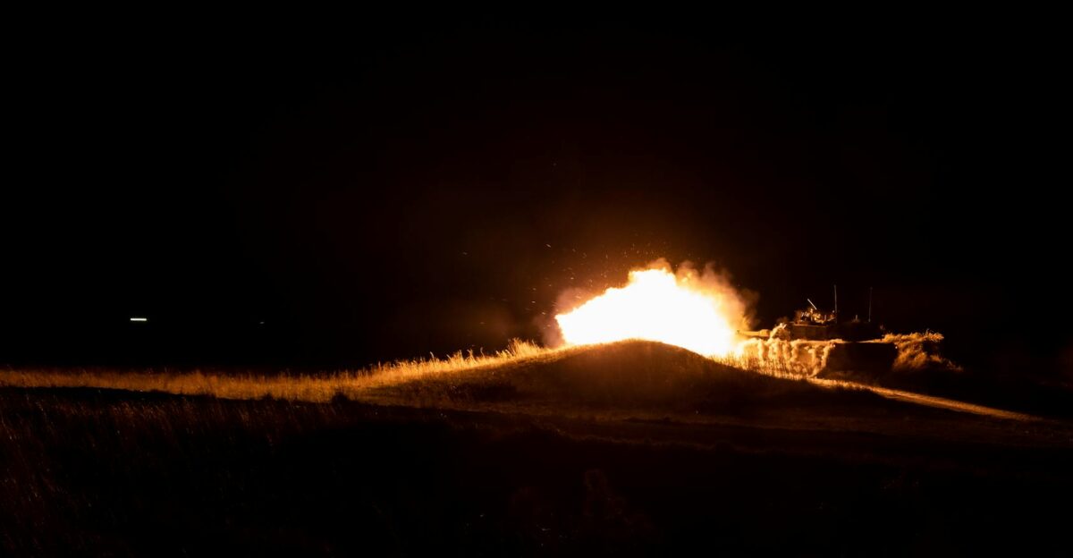 A powerful fireball eruption during nighttime military training creates a dramatic scene