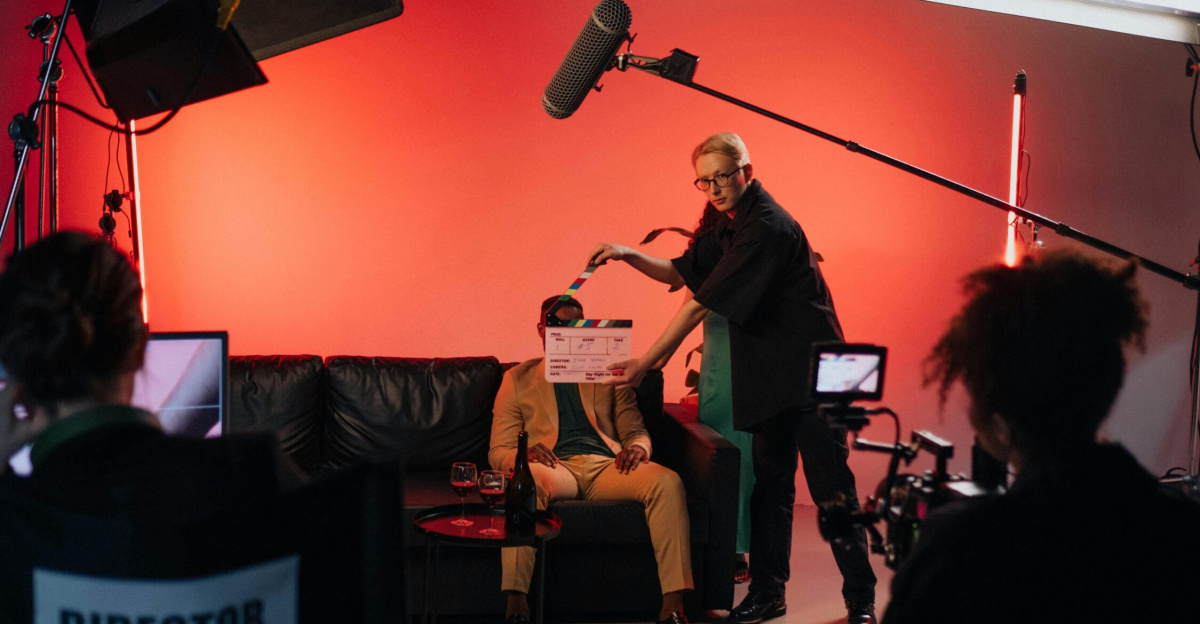 A behind-the-scenes look at a filming crew setting up a scene indoors with lighting equipment.