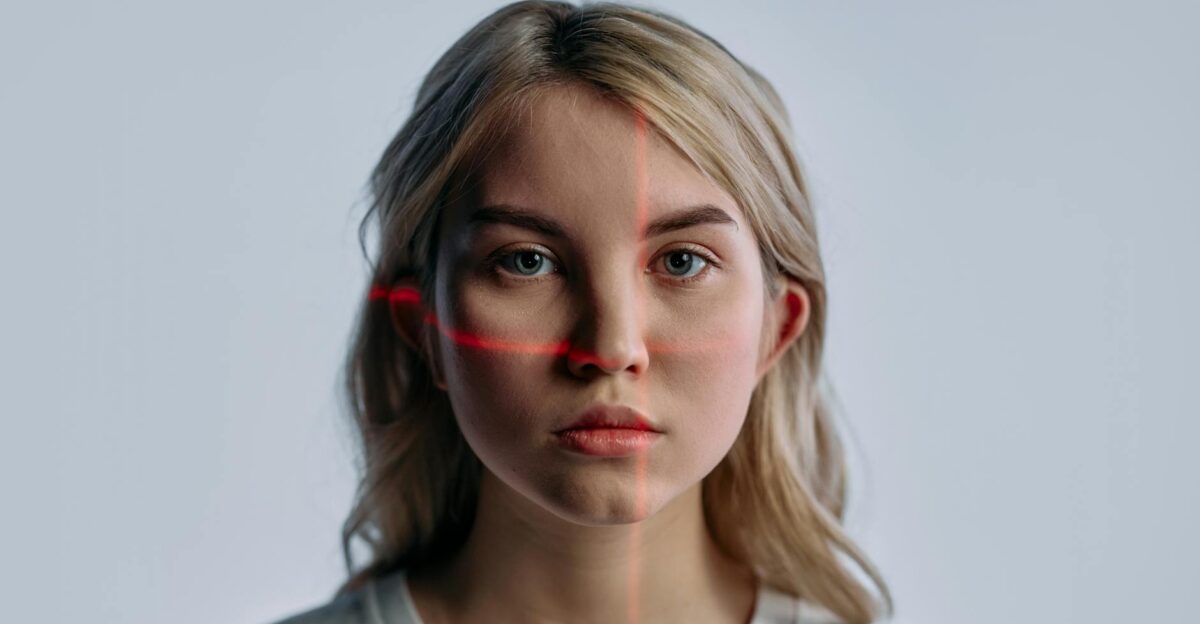 Close-up of a young woman with facial recognition lasers projected symbolizing future technology