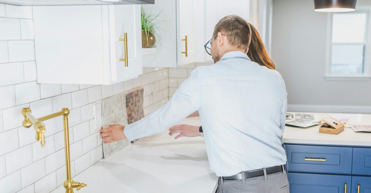 A couple choosing tiles in a modern kitchen setting discussing renovation ideas