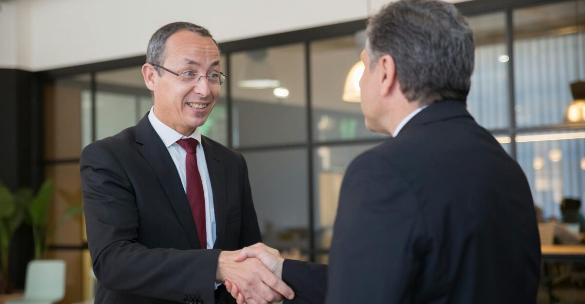 Two businessmen in suits shaking hands symbolizing a successful business deal