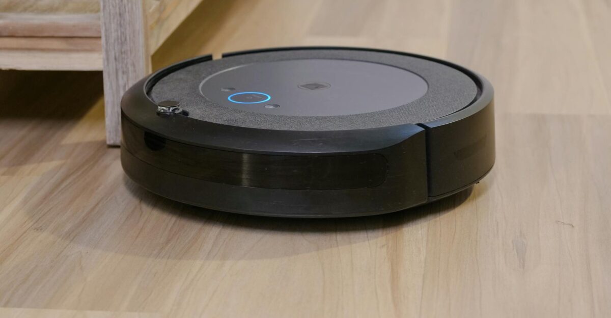 Autonomous vacuum cleaner navigating wooden floor indoors showcasing smart home technology