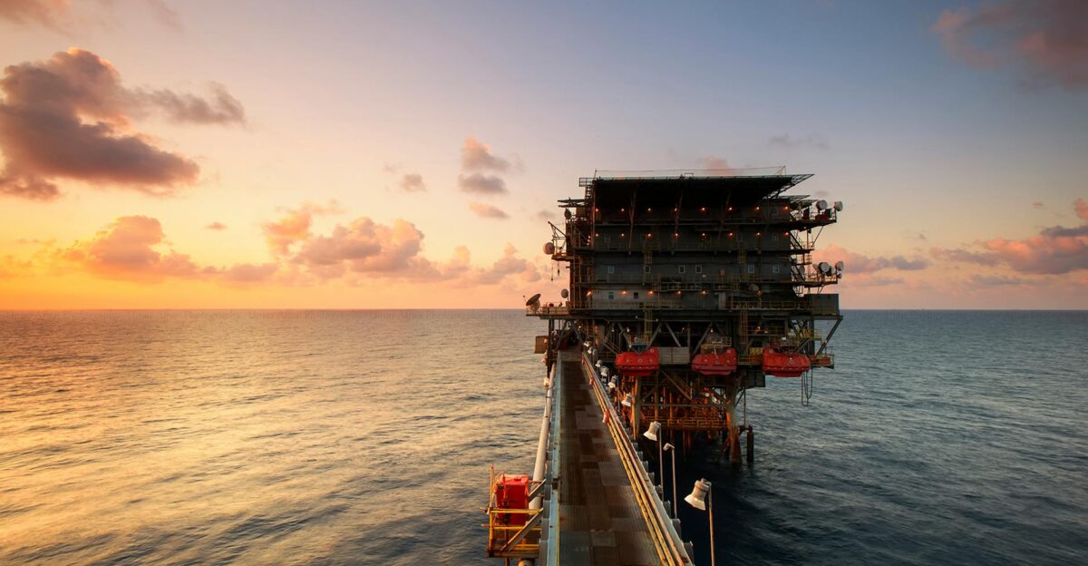 A breathtaking view of an oil platform on the ocean at sunset showcasing industrial beauty