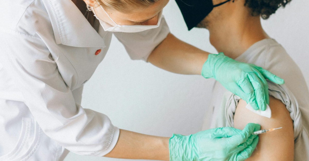 A healthcare worker gives a vaccine shot to a patient wearing a mask, highlighting medical safety and health precautions.