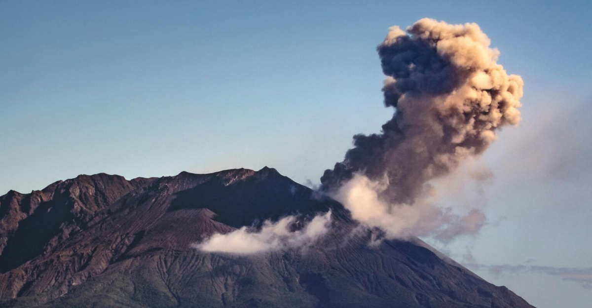 Spectacular eruption of Sakurajima Volcano with ash plume rising above Kagoshima Bay at dawn.
