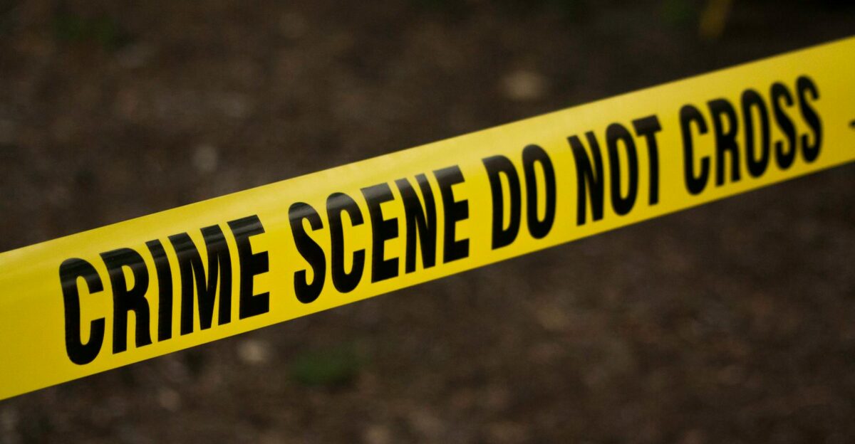 Close-up of crime scene tape with Do Not Cross text outdoors setting