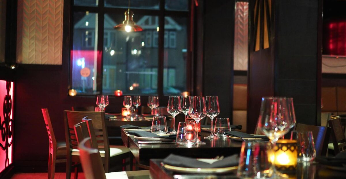 A sophisticated restaurant interior with elegant table setting and ambient candlelight creating a cozy atmosphere