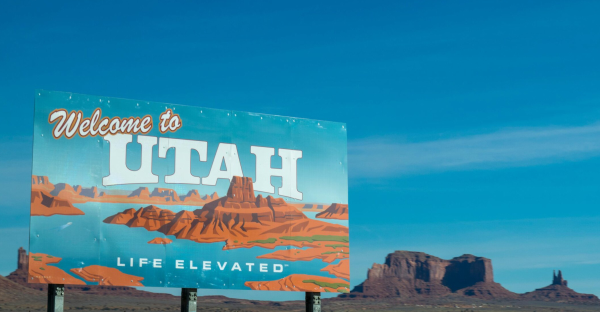 Scenic view of Utah welcome sign against desert and blue sky backdrop.