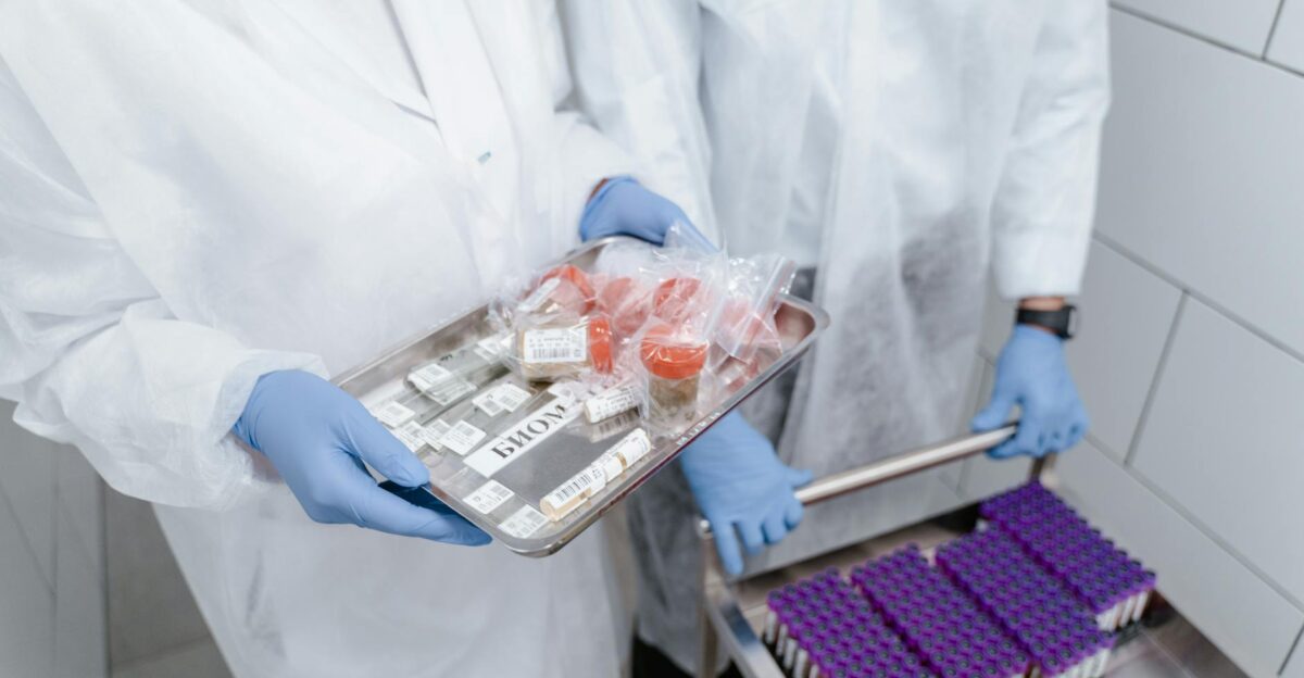 Scientists in protective gear manage medical samples in a lab setting ensuring safety and precision