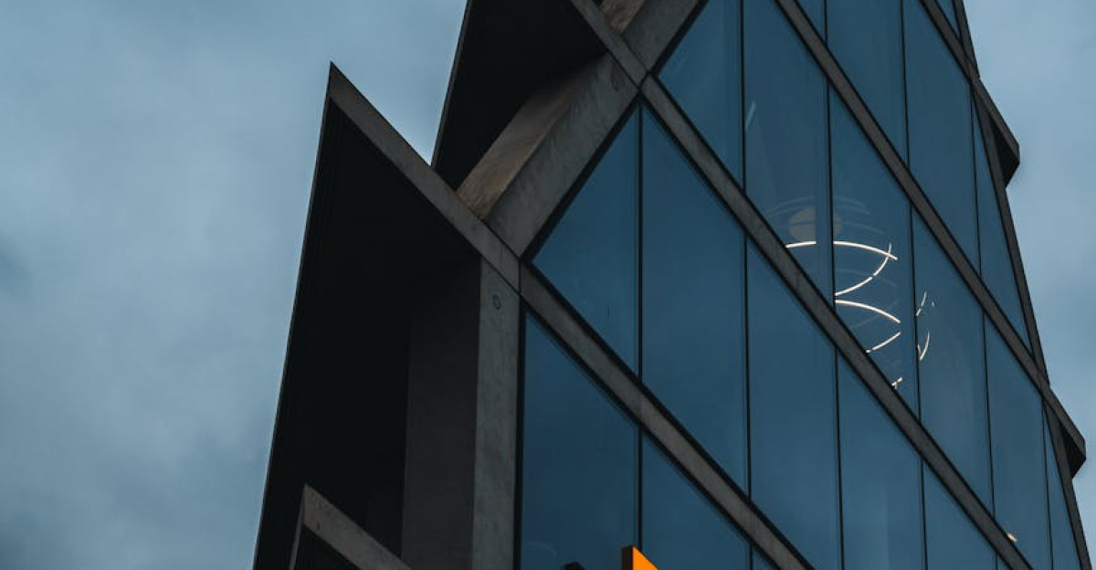 A modern Microsoft office skyscraper with glass facade against a cloudy evening sky