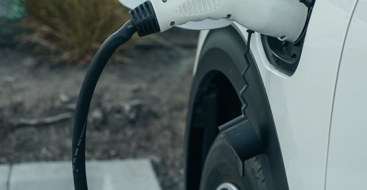 Close-up of electric vehicle connected to charging station outdoors