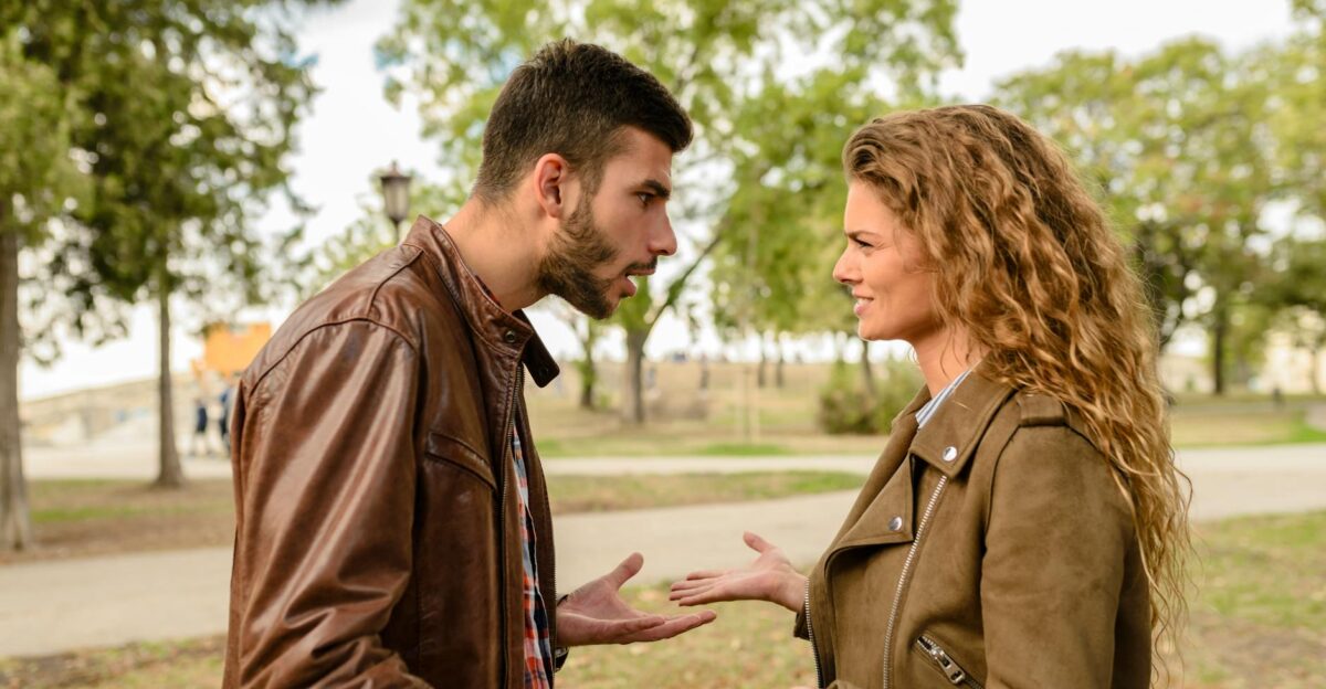 A couple having an argument outdoors expressing frustration and conflict