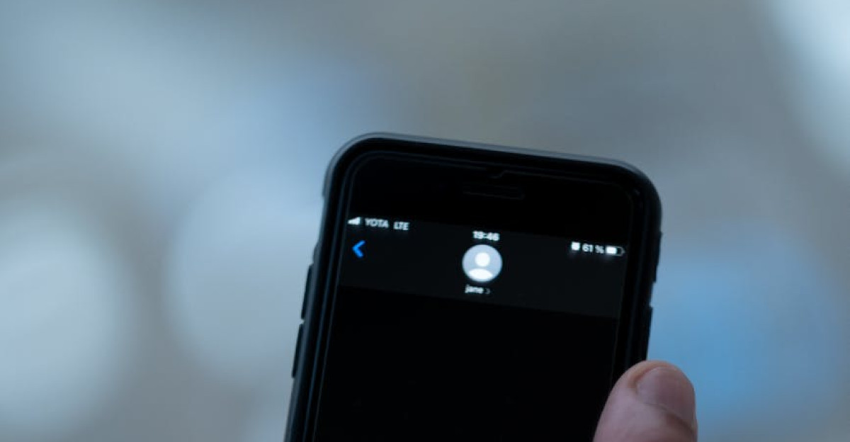 Close-up of a person texting on a smartphone indoors with a blurred background