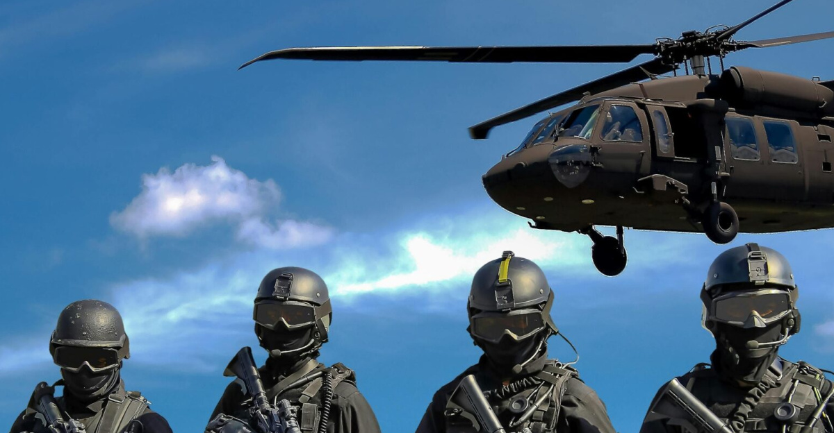 Special forces soldiers in tactical gear with helicopter overhead under a blue sky.