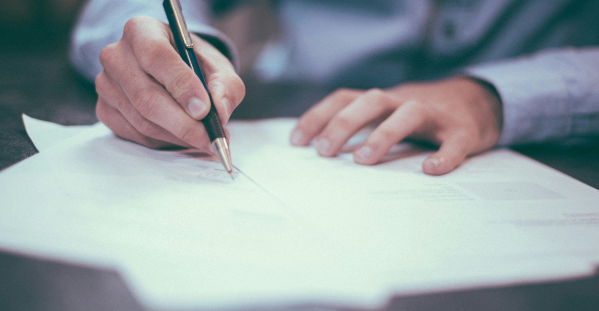 man writing on paper