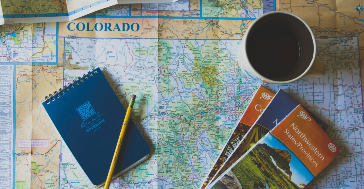 books and pencil on map