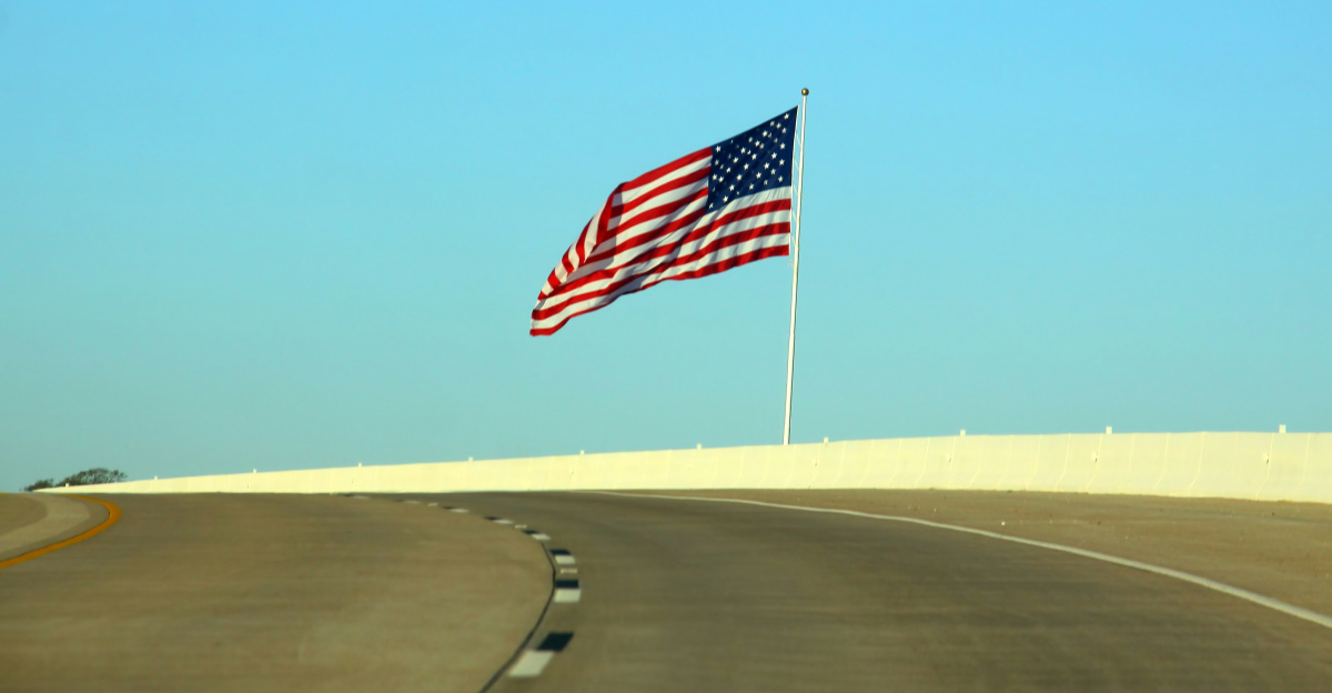 US flag beside road at daytime