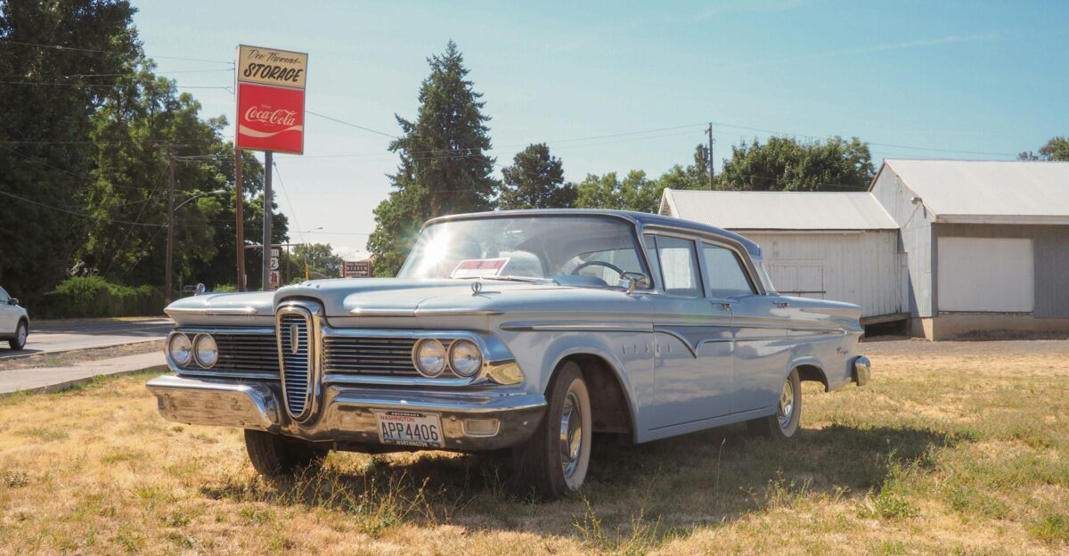classic teal sedan near house during daytime