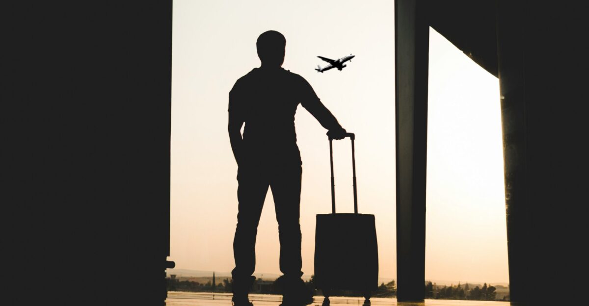 silhouette of man holding luggage inside airport