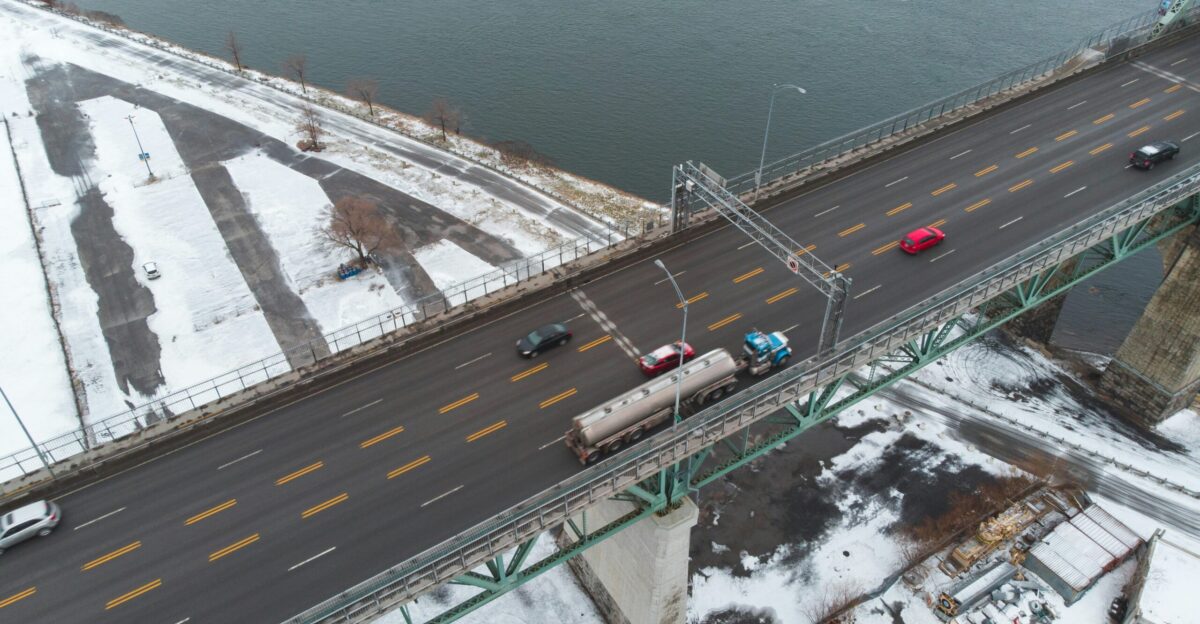 aerial photography of vehicles on steel bridge viewing blue body of water during daytime