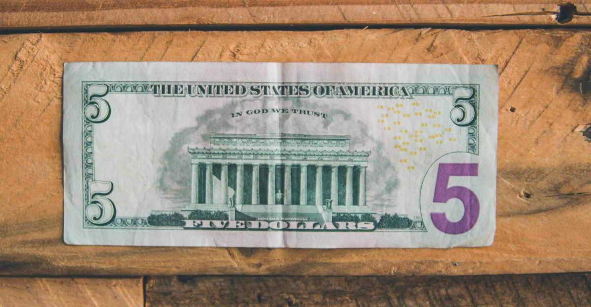 5 U.S dollar on brown wooden surface